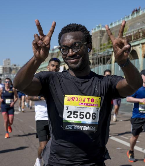 Marathon participant throws a peace sign to the camera