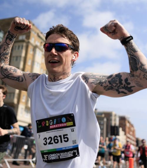 Runner punches their fists in the air mid-run
