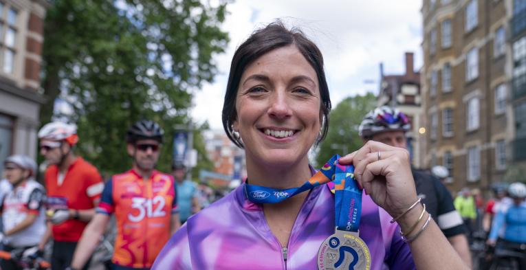 Woman holding her Ride London medal.