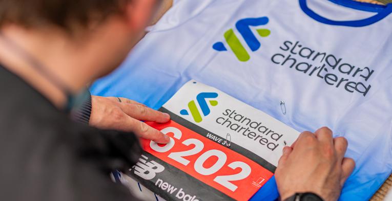 A runner attaches their Great City Race bib to their vest