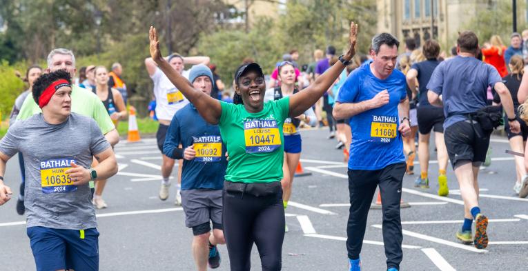 Participant at the Bath Half celebrates with arms in the air