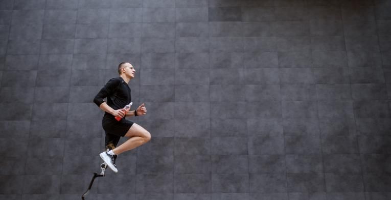 Sportsman with artificial leg running outside