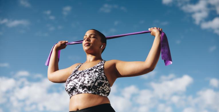 Woman uses a resistance band outdoors