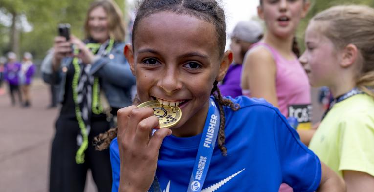Participant biting their medal at the Finish Line