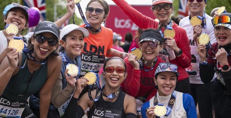 Participants pose at the Finish Line with their medals