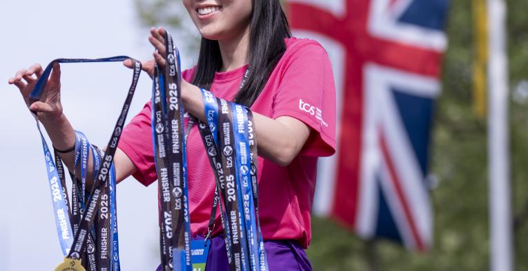 Volunteer handing out medals at the Finish Line
