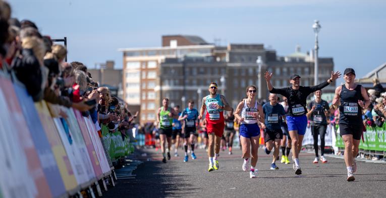 Participants and spectators on a sunny day at the Brighton Marathon