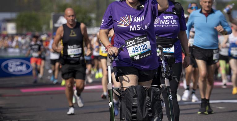 A participant using a frame walker leaves the Start Area
