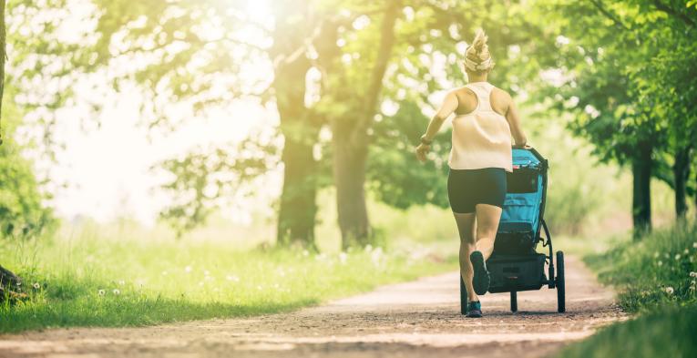 Young mother running with a pram