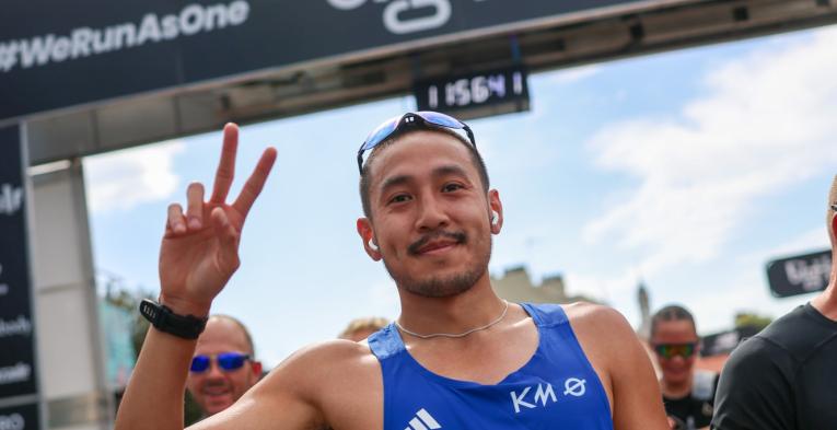 Participant throwing a peace sign at the Finish Line