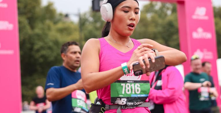 Runner stops their watch as they pass the Finish Line