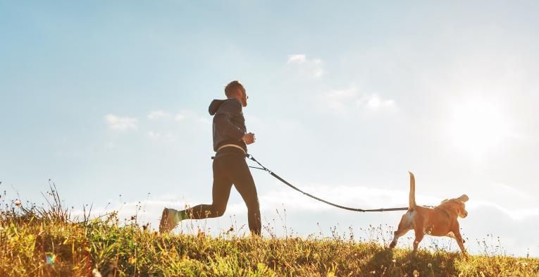 Man trail running with his dog