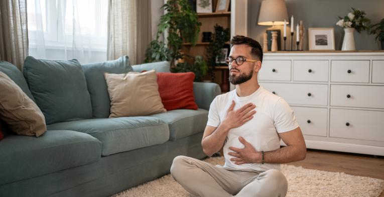 Man practising breathwork in his front room