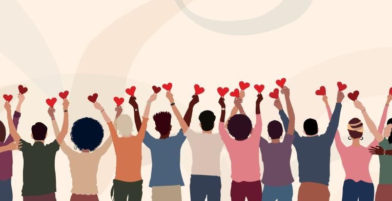 Crowd of people from behind holding up hearts 