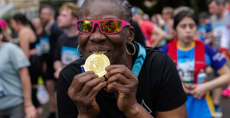 Participant biting their medal 