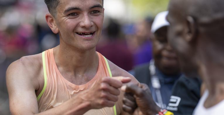Alex Yee fist bumps Eliud Kipchoge