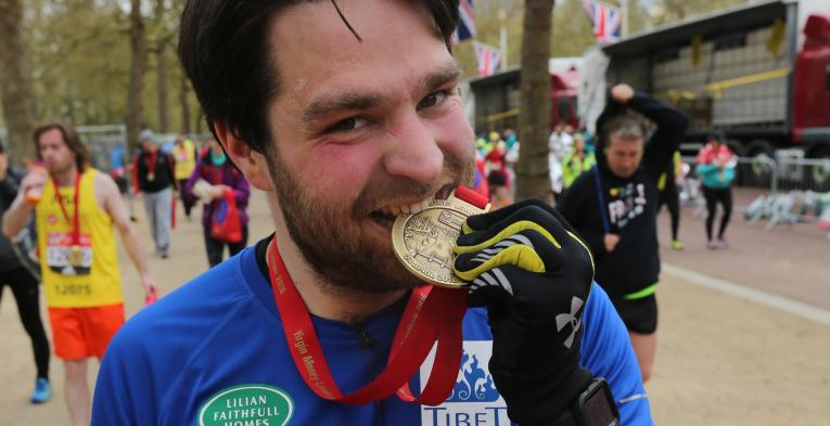 James Dunn bites his London Marathon medal