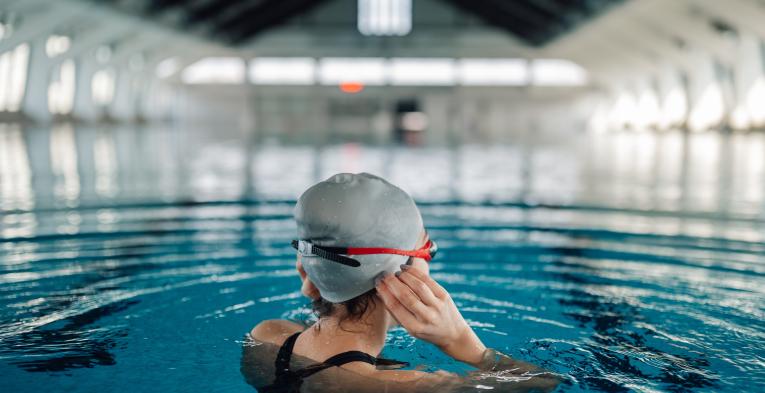 Women adjusting her swim cap in an indoor pool