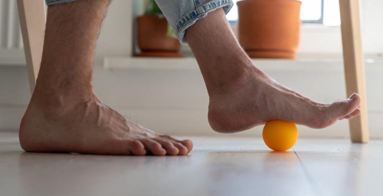 Someone rolling their foot on a massage ball 