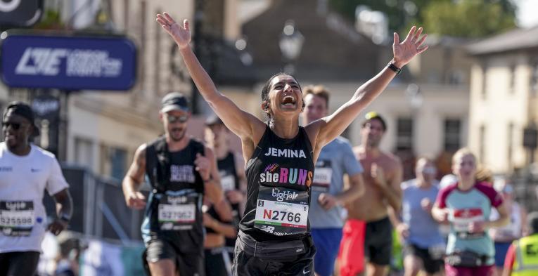 Runner cheers as they cross the Finish Line