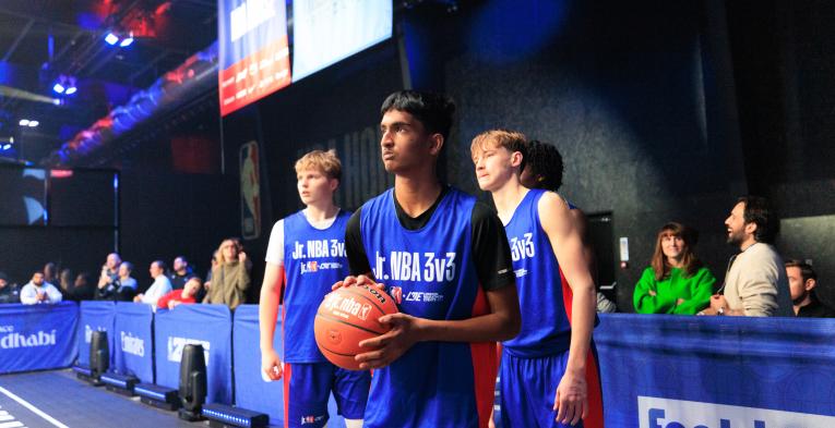 Three Junior NBA partcipants standing holding a basket ball