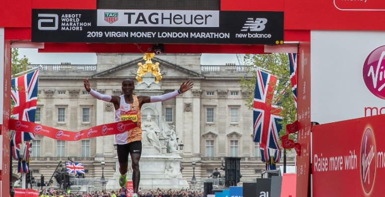 Kipchoge celebrates in front of the TAG Heuer clock after winning the 2019 Virgin Money London Marathon