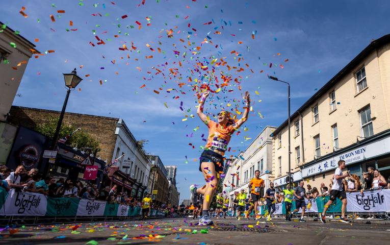 Big Half participant celebrates finishing the event in a cloud of confetti