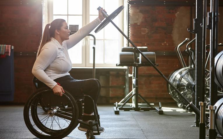 Wheelchair user in the weights area of the gym