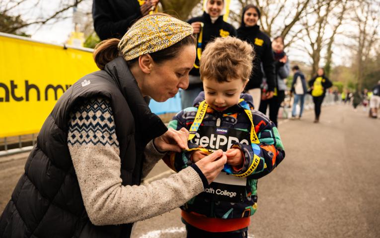 Bath Miles finishers looking at their medal