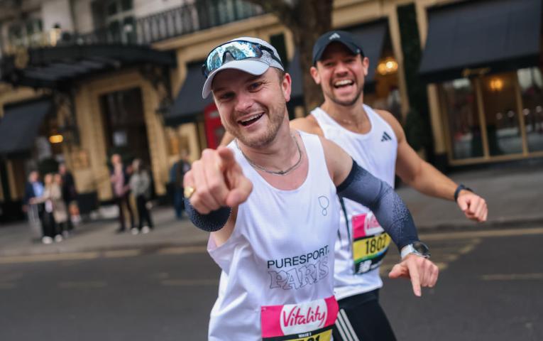 Runners point at the camera