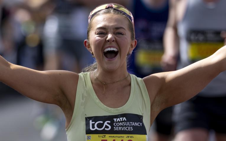 A runner cheers while on Tower Bridge 