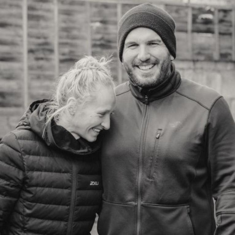 A lady smiling and leaning against a man who is also smiling.