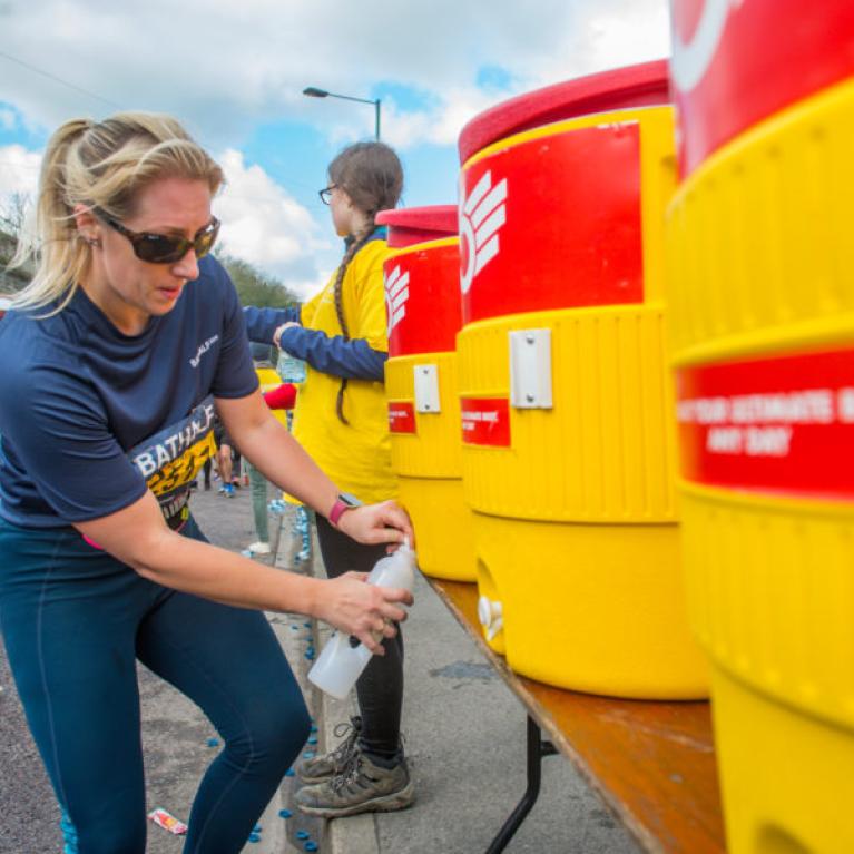 A lady re-fuelling her water bottle with water