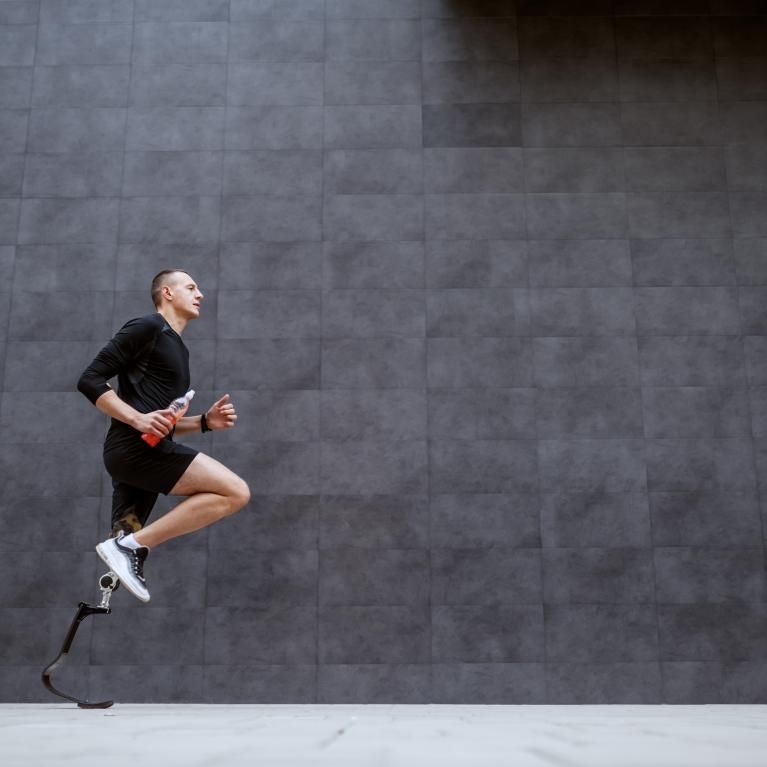 Sportsman with artificial leg running outside
