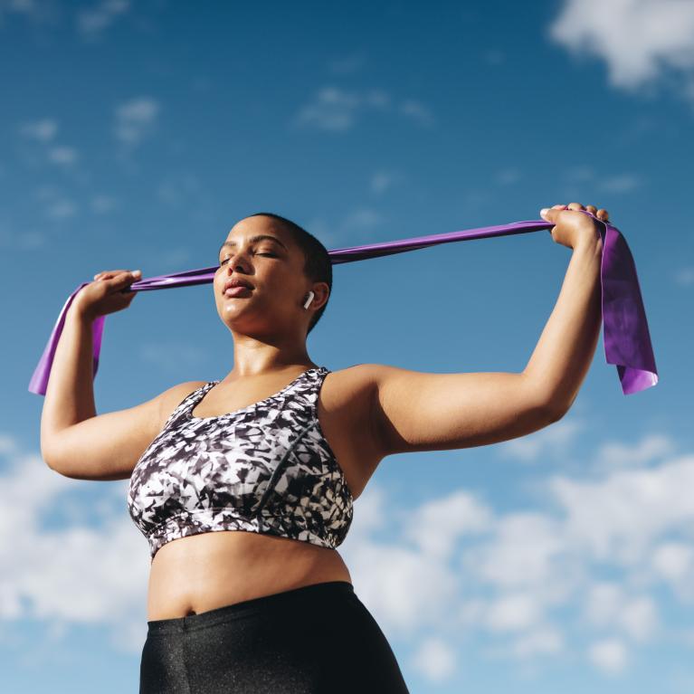 Woman uses a resistance band outdoors
