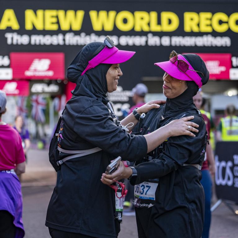 Participants embrace at the Finish Line of the 2025 TCS London Marathon