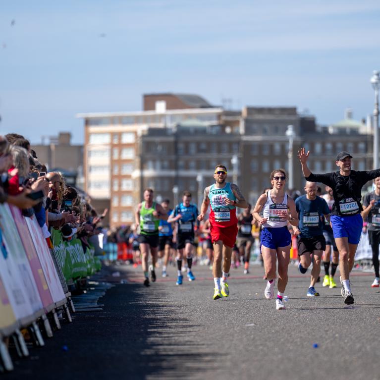 Participants and spectators on a sunny day at the Brighton Marathon