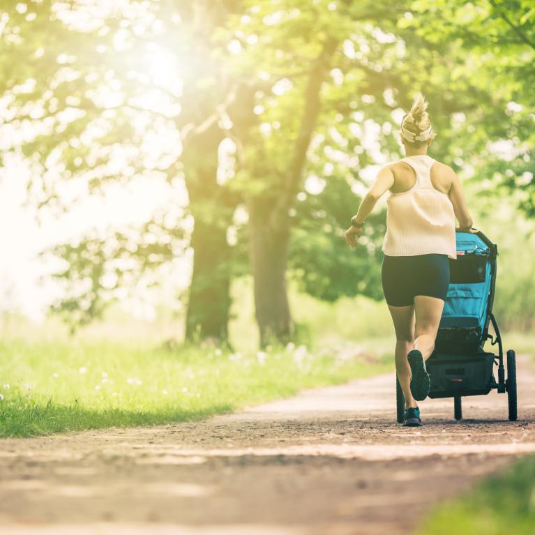 Young mother running with a pram