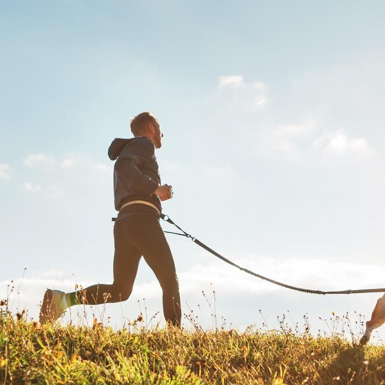 Man trail running with his dog 