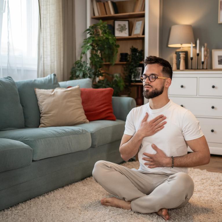 Man practising breathwork in his front room