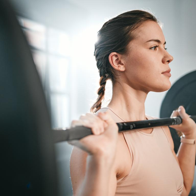 Woman holding a barbell in the front rack position 