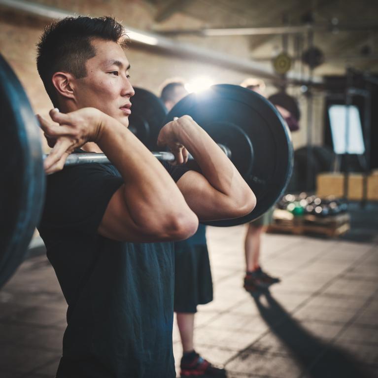Man with a barbell in front rack