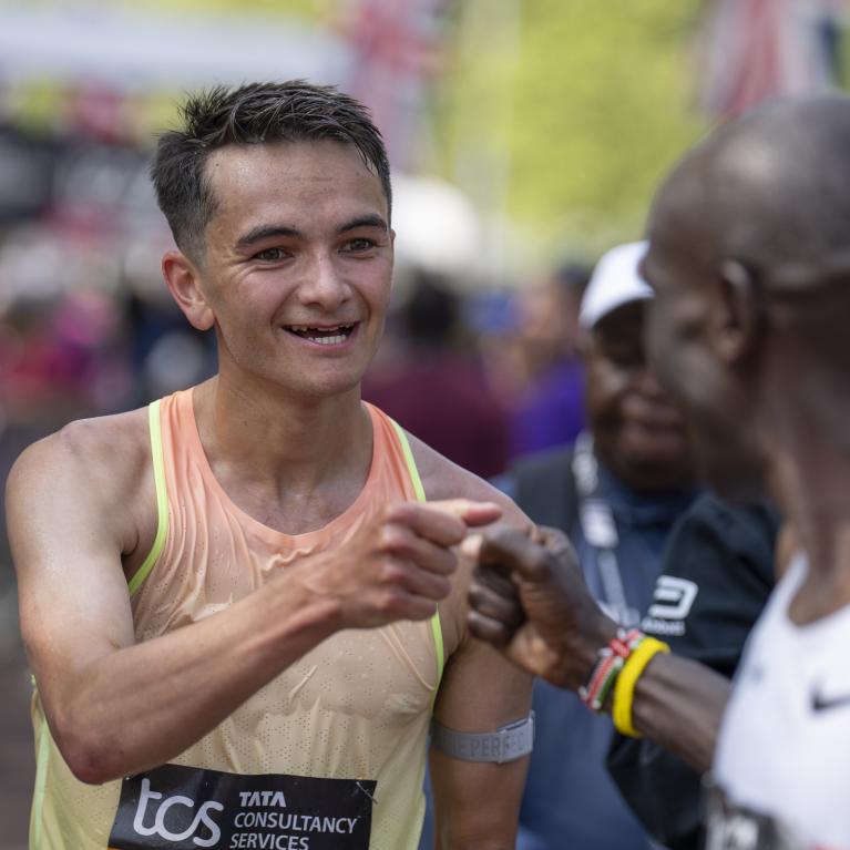 Alex Yee fist bumps Eliud Kipchoge