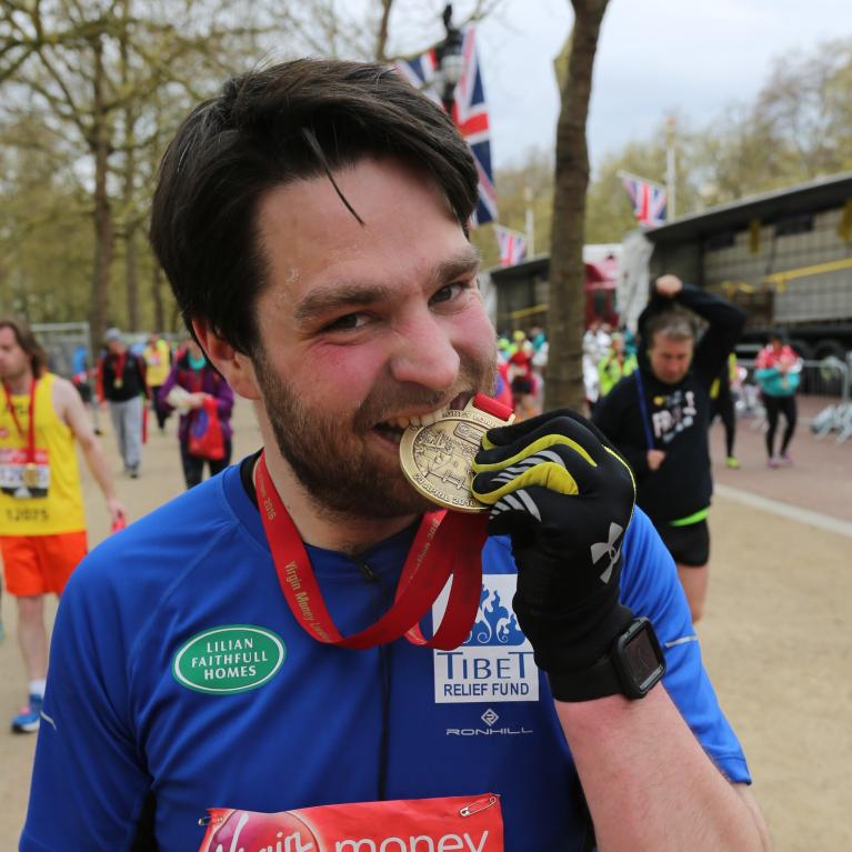 James Dunn bites his London Marathon medal