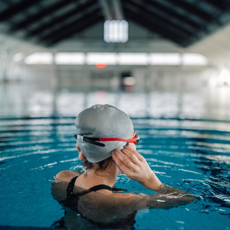 Women adjusting her swim cap in an indoor pool