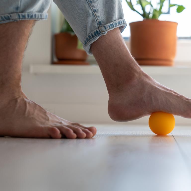 Someone rolling their foot on a massage ball 