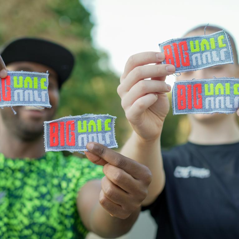 Runners holding up Big Half patches