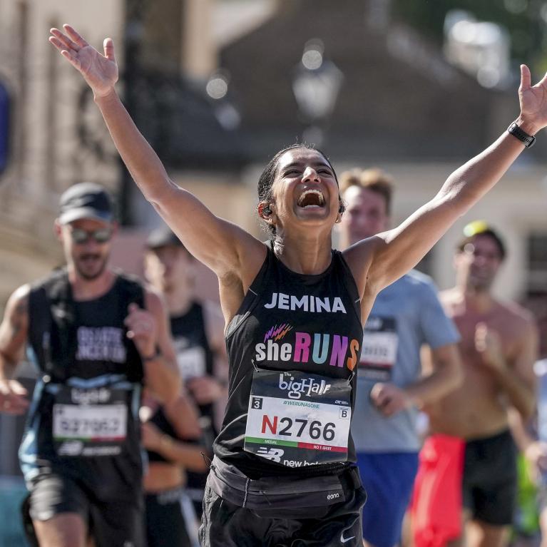 Runner cheers as they cross the Finish Line