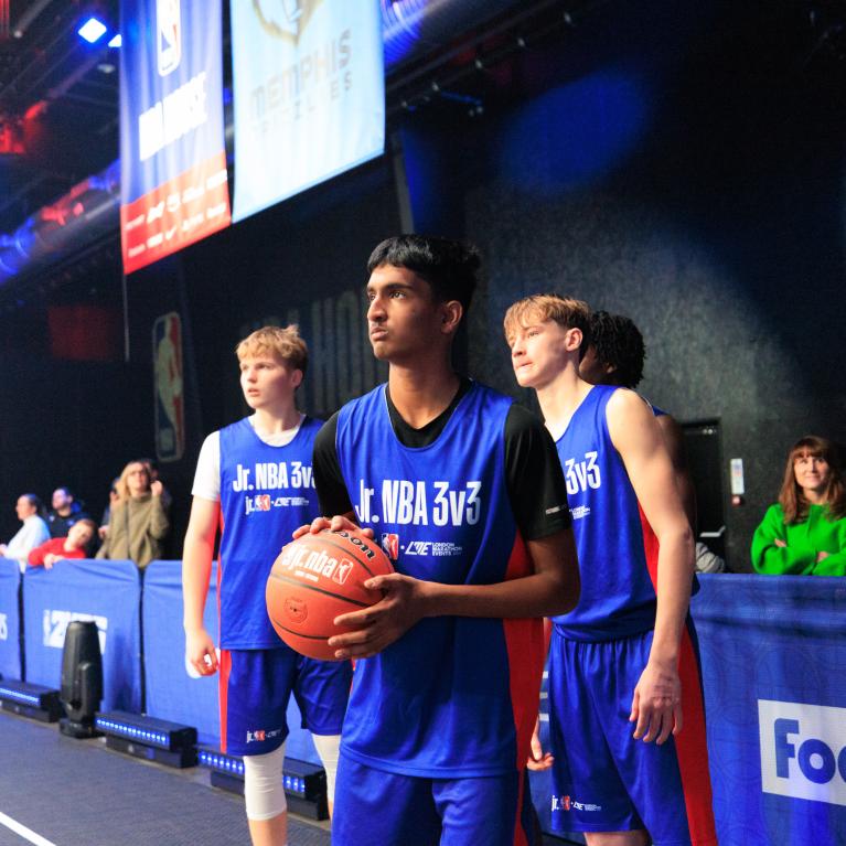 Three Junior NBA partcipants standing holding a basket ball