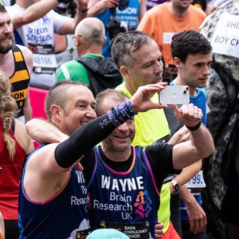 Photo of participants at the TCSLM 2023, including someone dressed as a Rhino and two men taking a selfie
